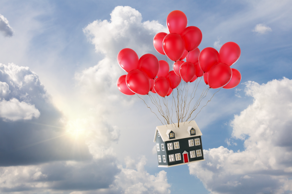 Image of a home rising through the air on balloons, representing increasing housing prices.