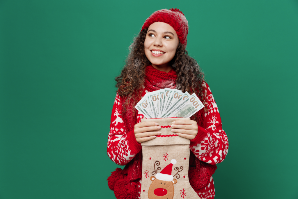 A woman who took out a holiday loan is happily making plans for the season. She's dressed in a holiday sweater and hat.