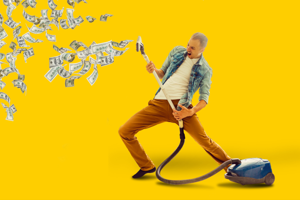 Spring Clean Your Finances image of a man vacuuming up his money, holding the vacuum like a guitar.